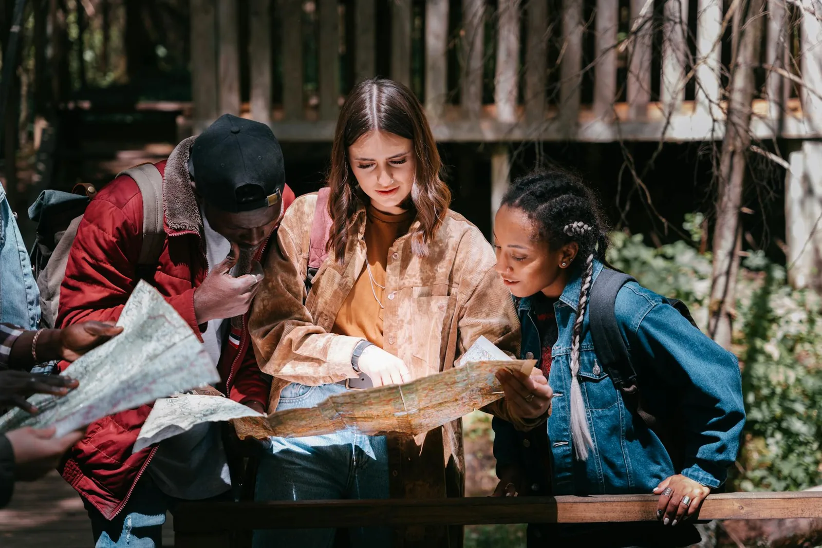A group of friends studying a map outdoors while planning a trip
