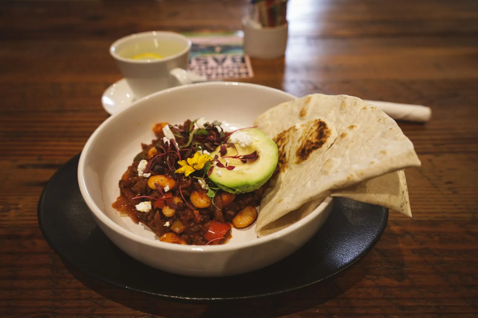 A bowl of hearty chili topped with avocado, the kind judged at a cook-off
