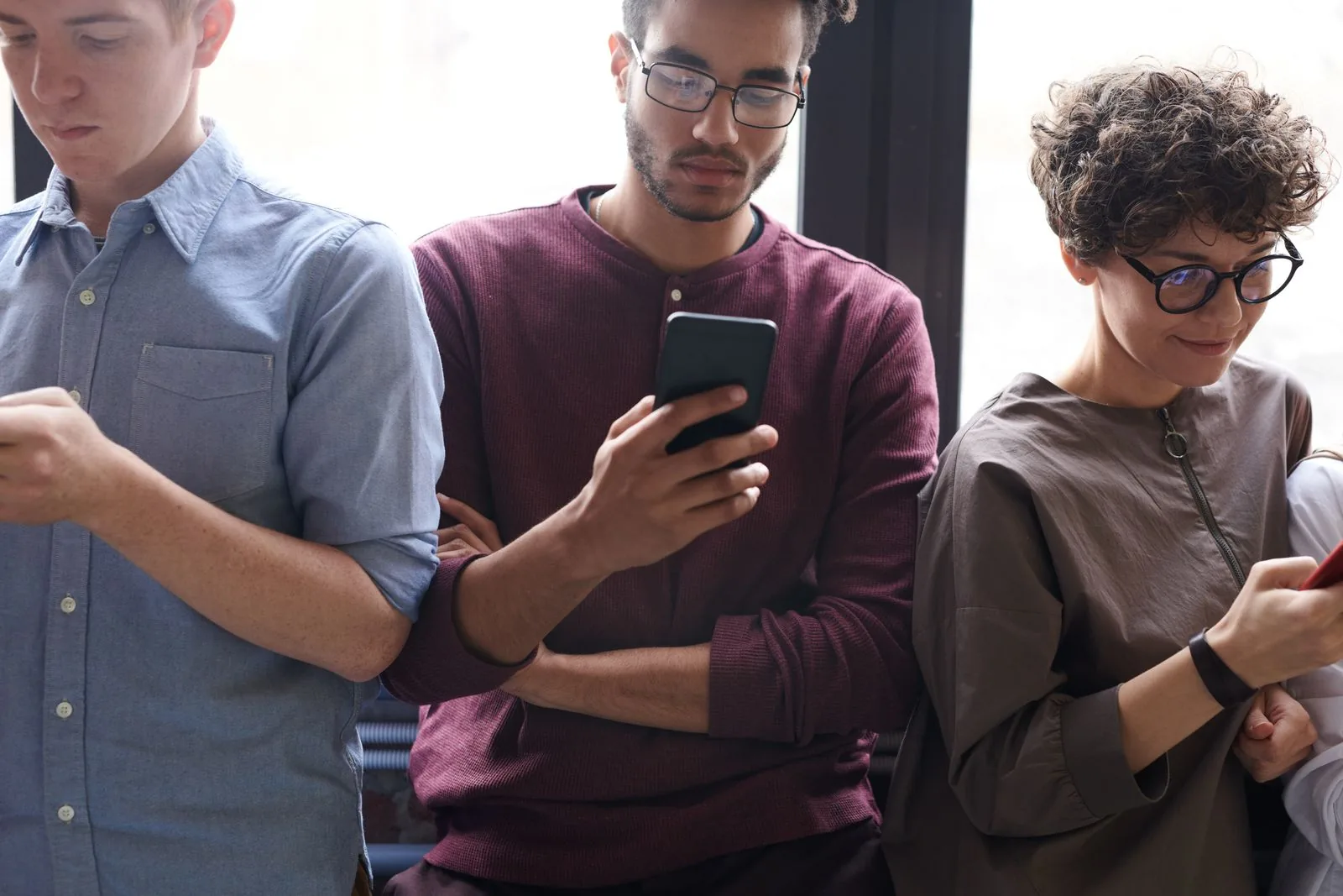 A diverse group of friends each voting on their phones