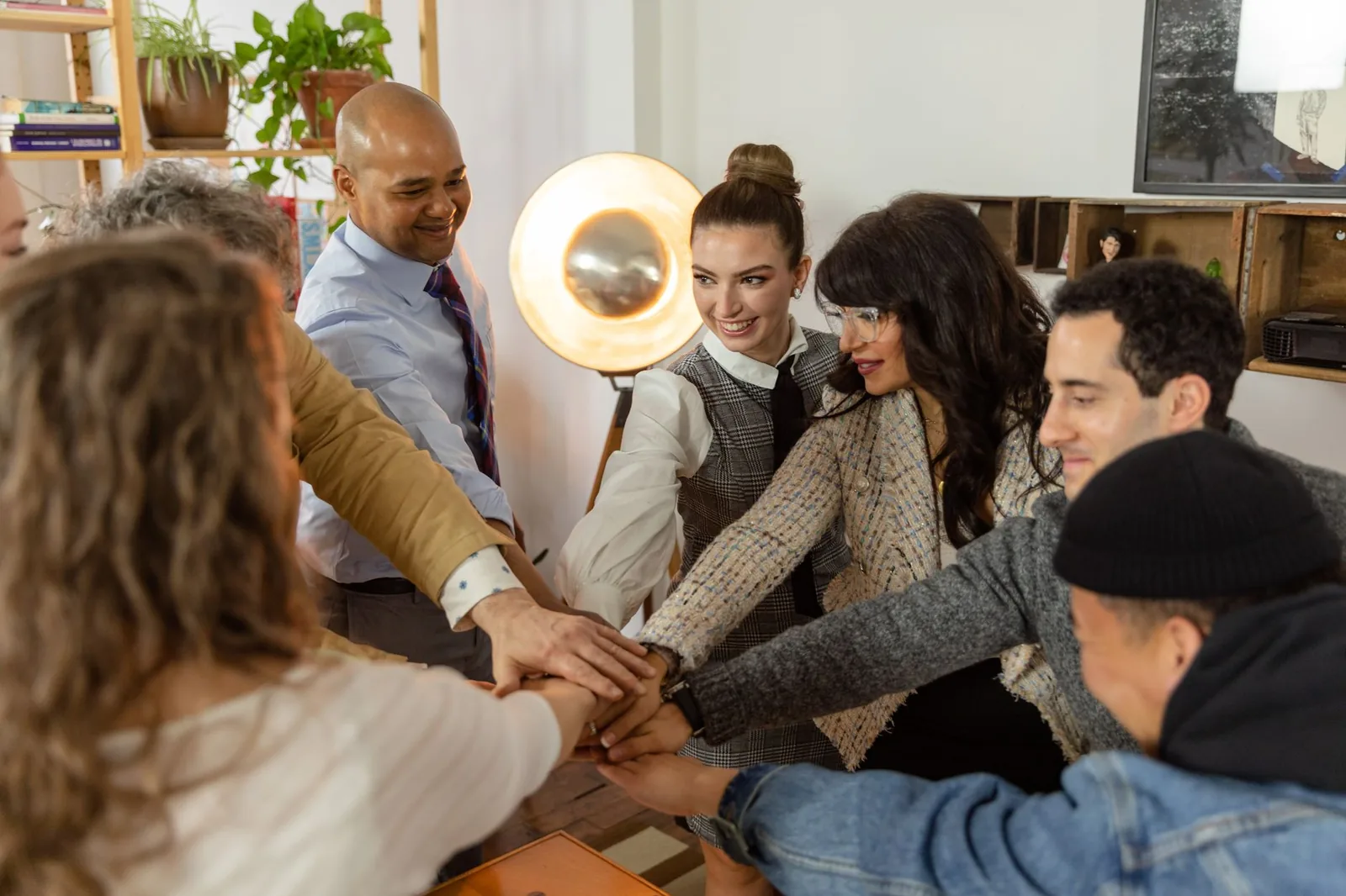 A diverse team putting their hands together in a huddle